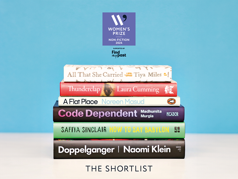 The six shortlisted Women's Prize for Non-Fiction titles stacked on a white table.